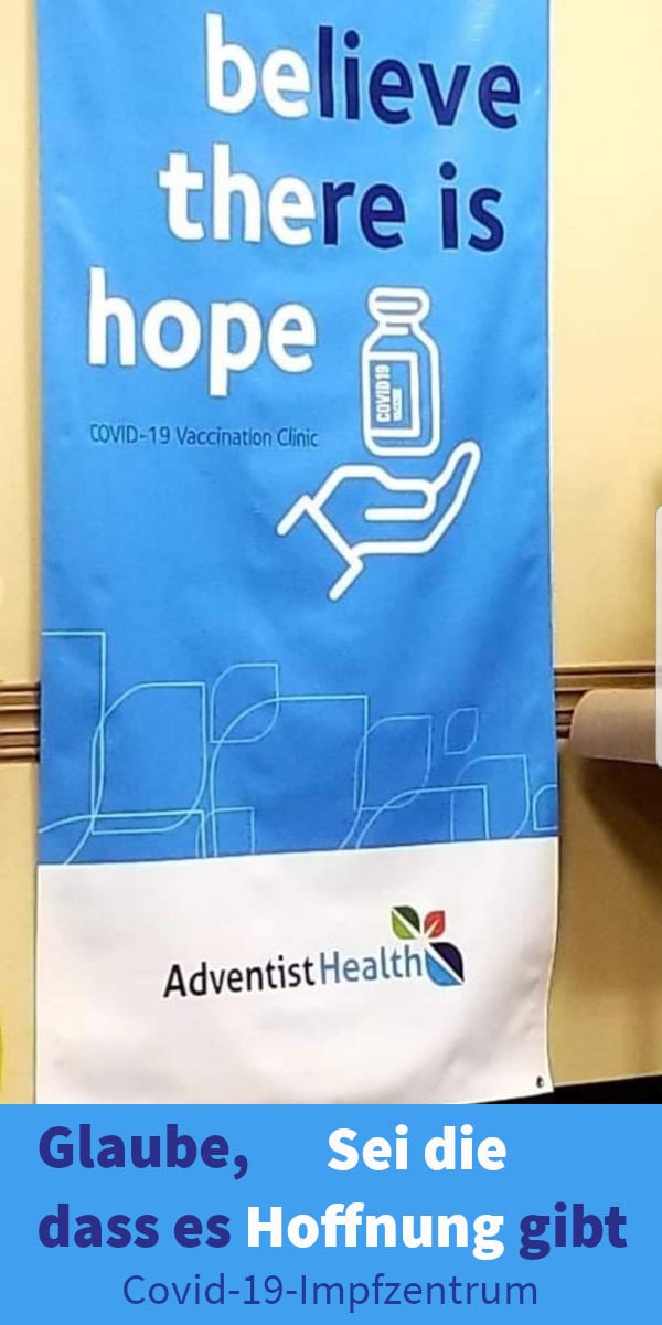 Ein Banner mit der Aufschrift "believe there is hope" über einer grafischen Darstellung einer Hand, die eine Impfstoffflasche hält, darunter die Worte "COVID-19 Vaccination Clinic". Unten ist das Logo von Adventist Health abgebildet, gefolgt von einem deutschen Text „Glaube, dass es Hoffnung gibt, Covid-19-Impfzentrum“.